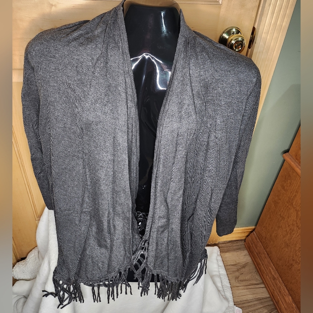 Women's open cardigan with fringes on the bottom.